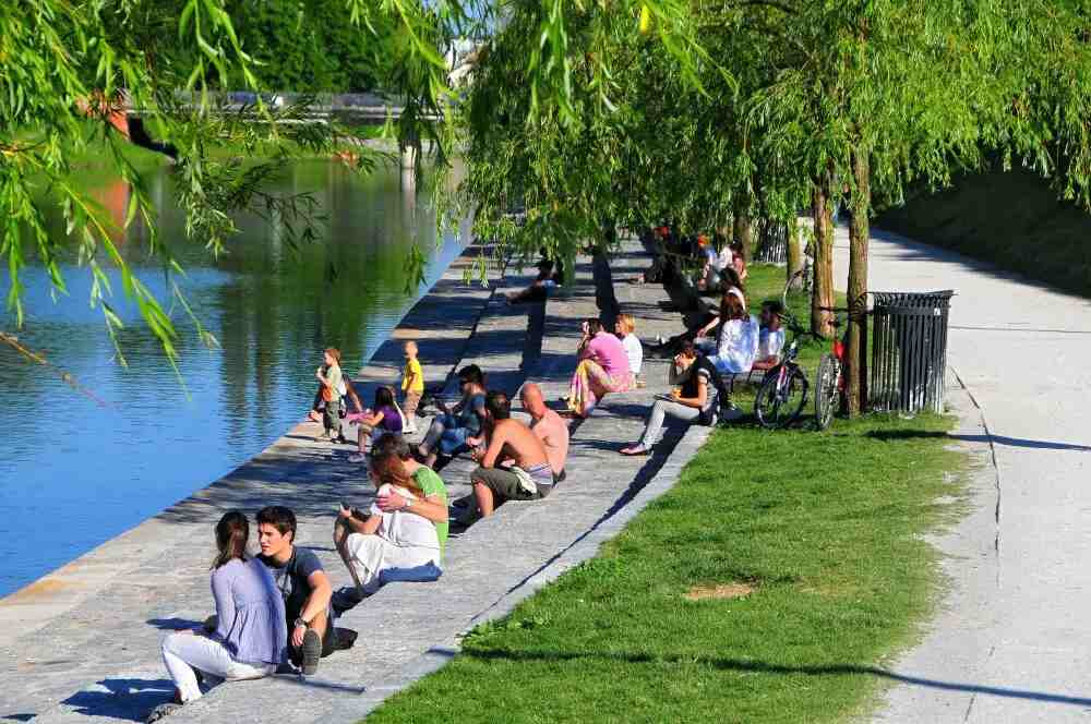 People enjoying summer sun on terraced Ljubljana beach by river Ljubljanica