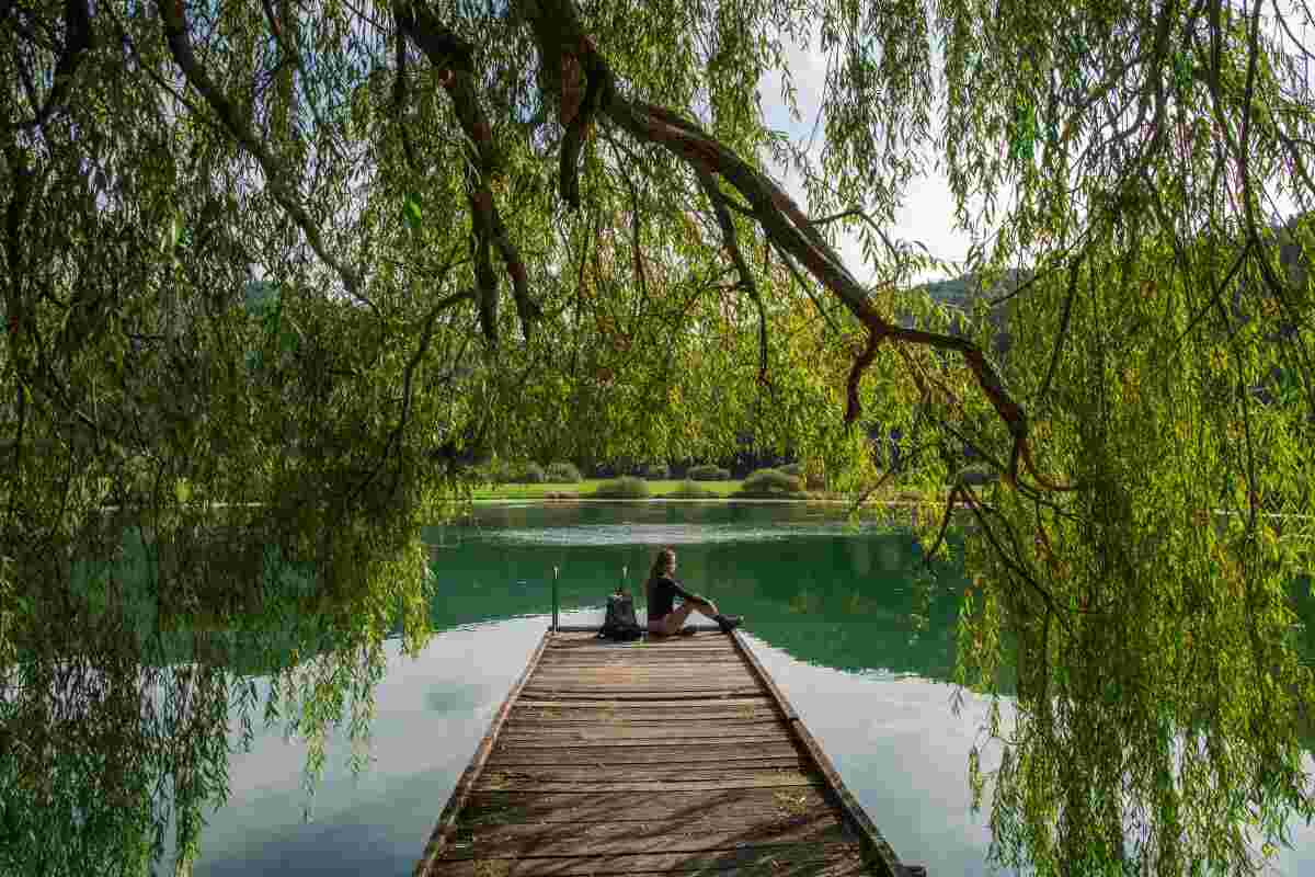 A young lady sitting on a dock of Podpec lake near Ljubljana in