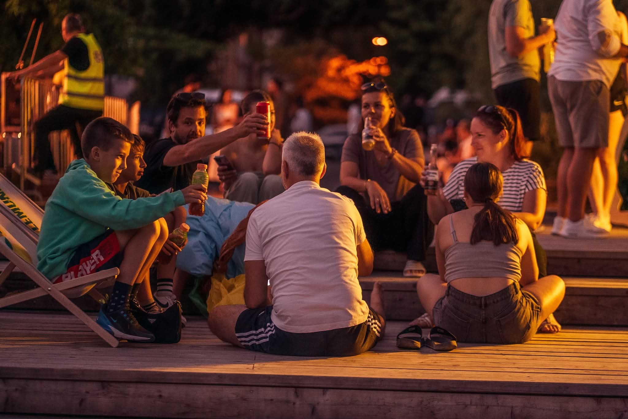 Kids sitting on wooden steps enjoying a summer evening in Ljubljana with friends and family.