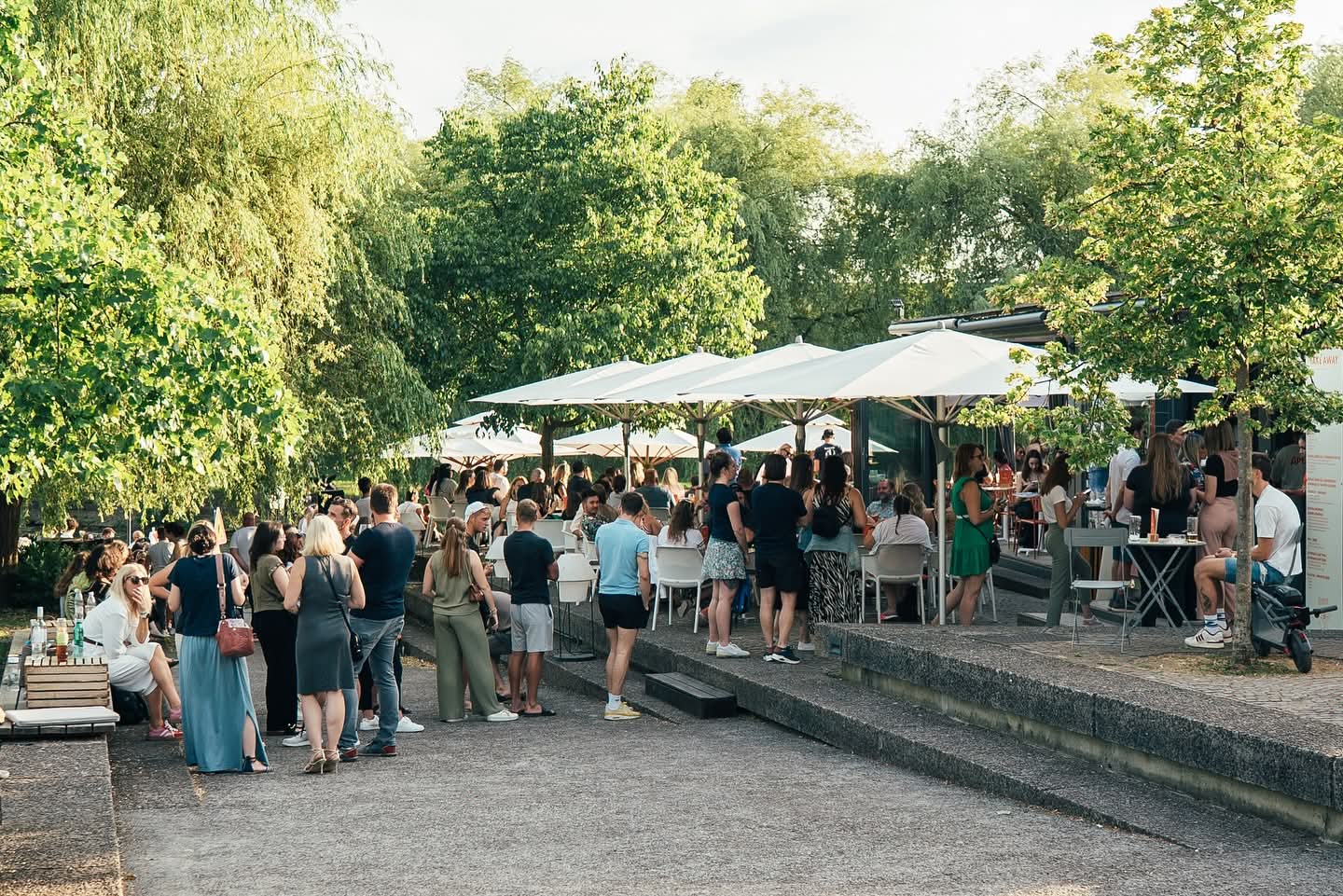 Lush green riverside park in Ljubljana with boating and scenic views, perfect for relaxation and outdoor activities.