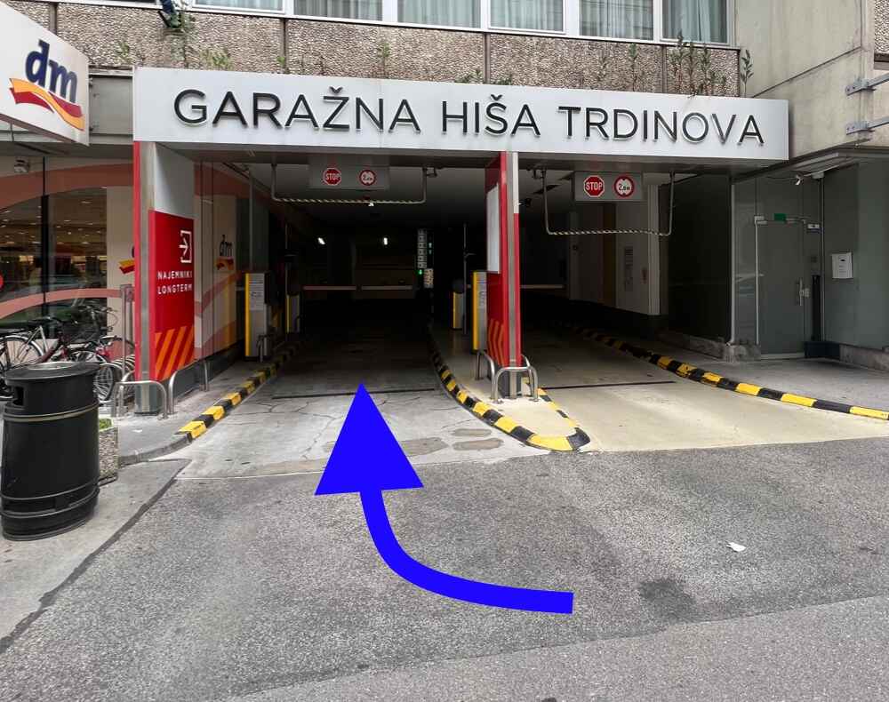 Entrance to the Trdinova parking garage (Garažna hiša Trdinova) next to a DM store and Avant2Go car rental in Ljubljana, Slovenia.